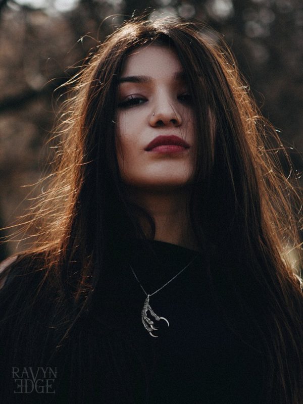 Woman in a forest wearing a silver ravenclaw necklace