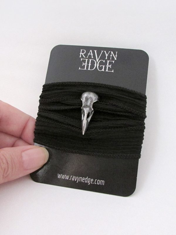 Small sterling silver raven skull charm on silk ribbon bracelet