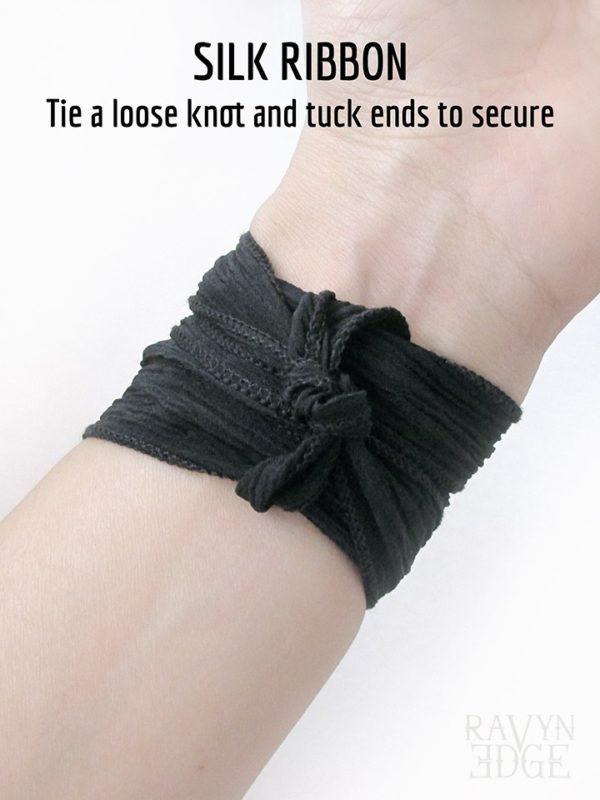 The tied ends of the black silk ribbon bracelet