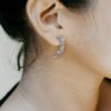 Woman wearing a sterling silver dragon claw half hoop earring