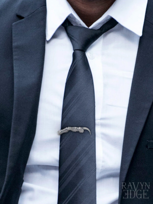 Crow claw tie bar clip on a man wearing a dark blue suit and necktie