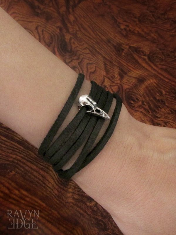 Tiny sterling silver raven skull charm on a black leather wrap bracelet