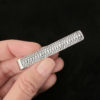 Hand holding a silver dragon scale mens tie bar