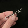 Hand holding a dragon scale mens tie bar clip