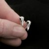 Small silver stud earrings shaped like little raven skulls