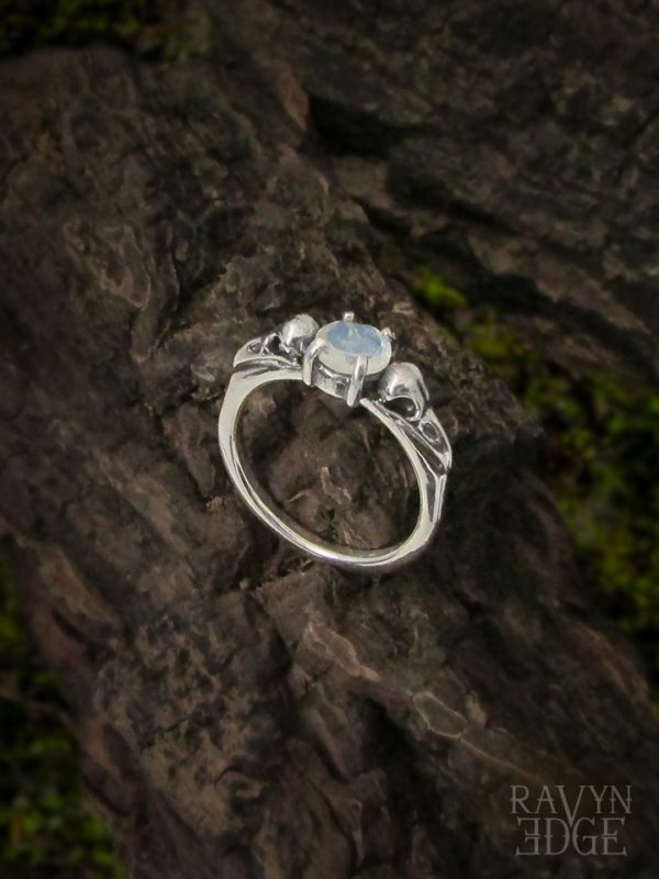 Two dainty raven skulls on a moonstone wedding ring