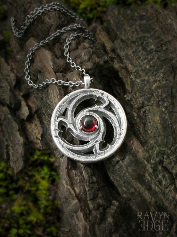 Triskele window necklace in sterling silver with garnet