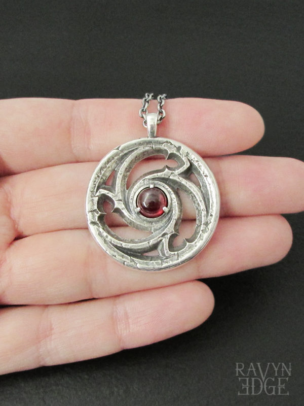 Sterling silver triskele necklace with garnet
