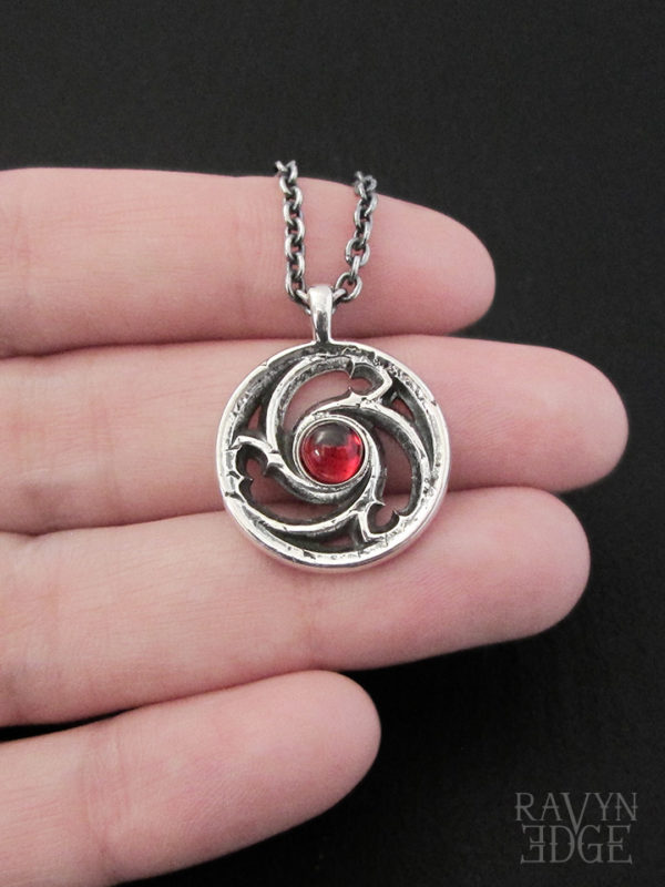Small sterling silver triskelion gothic window necklace with garnet stone