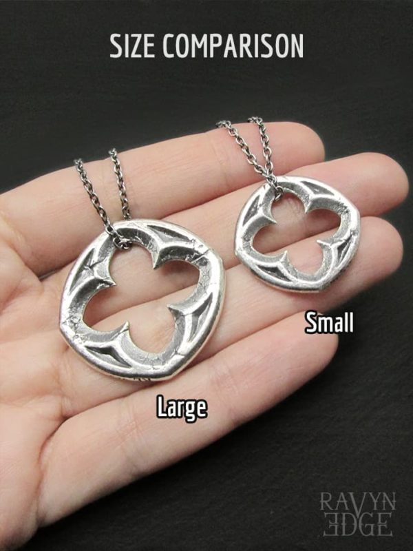 Size comparison of small and large silver quatrefoil window necklaces