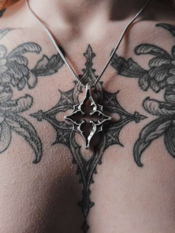 Kellsey wearing the silver star necklace in the center of her quatrefoil gothic tracery tattoo that inspired the pendant necklace.
