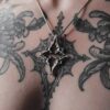 Kellsey wearing the north star necklace in the center of her gothic tracery tattoo that inspired the pendant necklace.