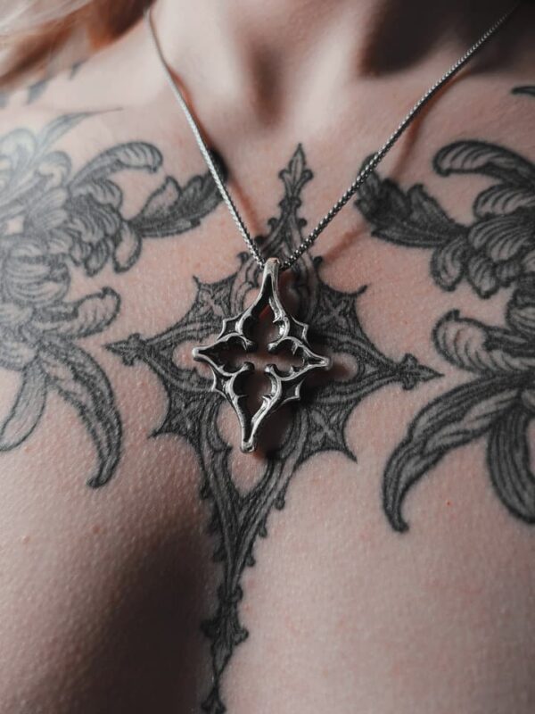 Kellsey wearing the north star necklace in the center of her gothic tracery tattoo that inspired the pendant necklace.