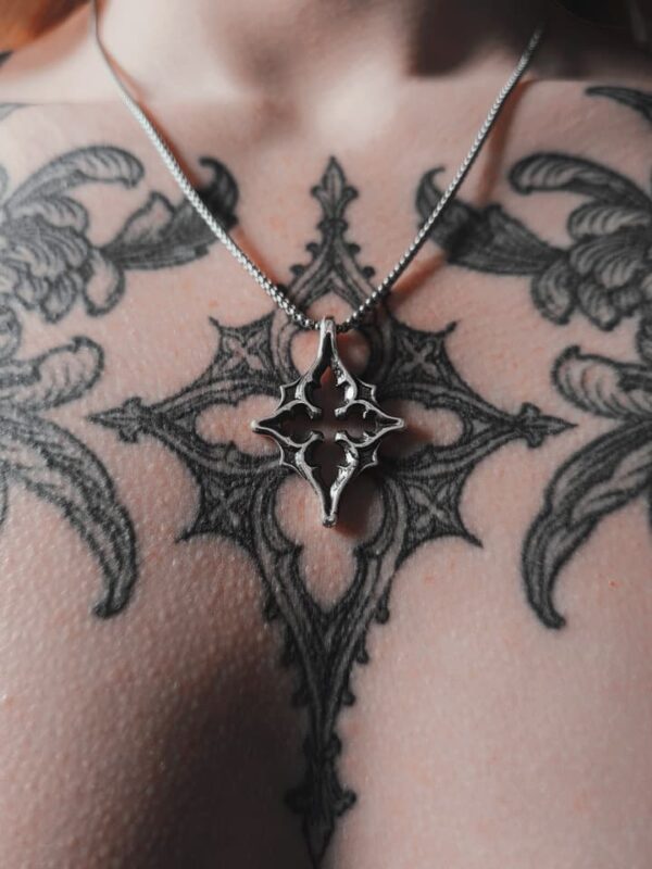 Kellsey wearing the north star necklace in the center of her gothic tracery tattoo that inspired the pendant necklace.